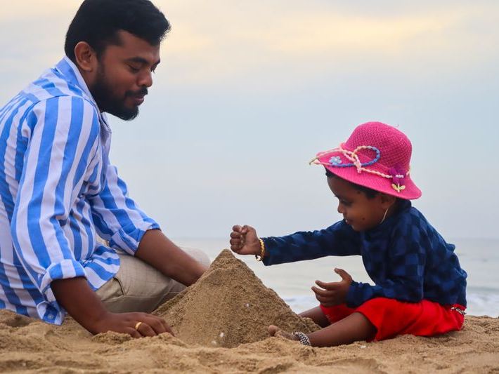 Father and child building a sandcastle on a sunny beach