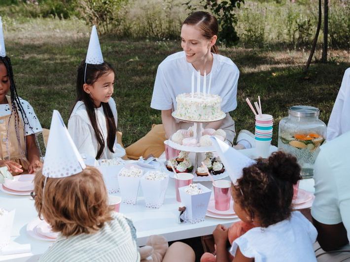 Family celebrating a child's outdoor birthday garden party
