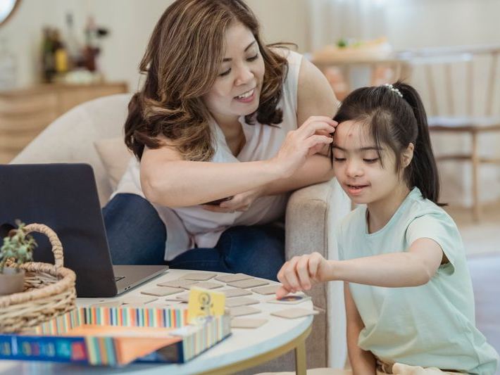 Mother and daughter playing a board game together at home