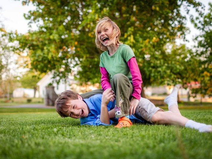 Two young girls laughing on a sunny park playground