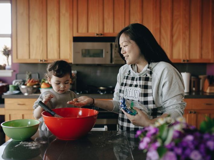 Mother and daughter sharing a joyful baking moment in the kitchen