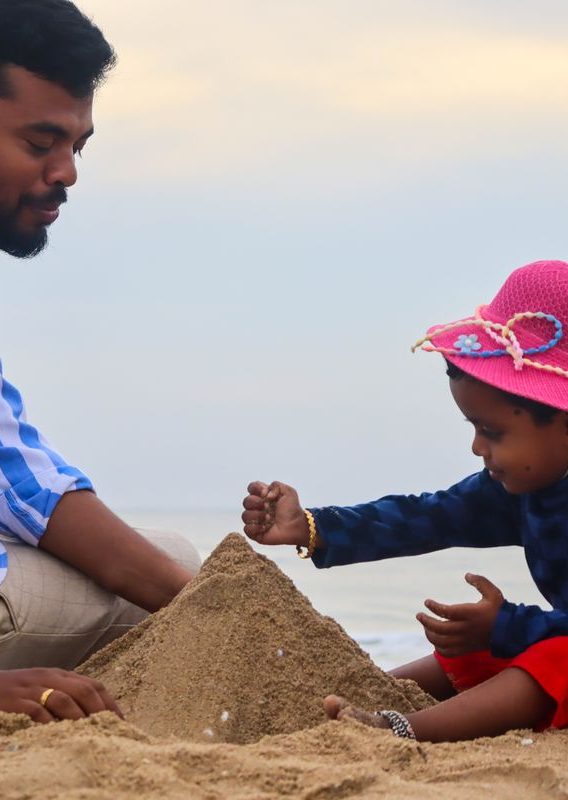 Father and child building a sandcastle on a sunny beach