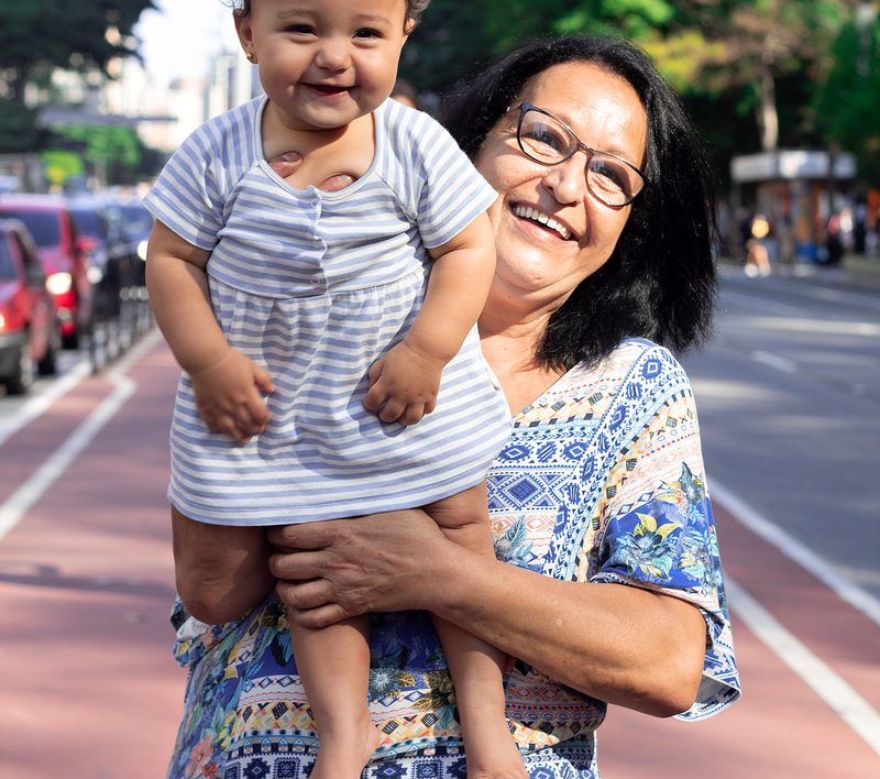 Grandmother and grandchild laughing together in a sunny park